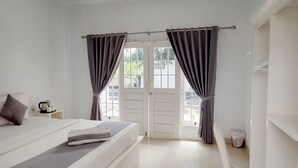 Une chambre à coucher avec un lit, des rideaux, une table de chevet et une fenêtre.