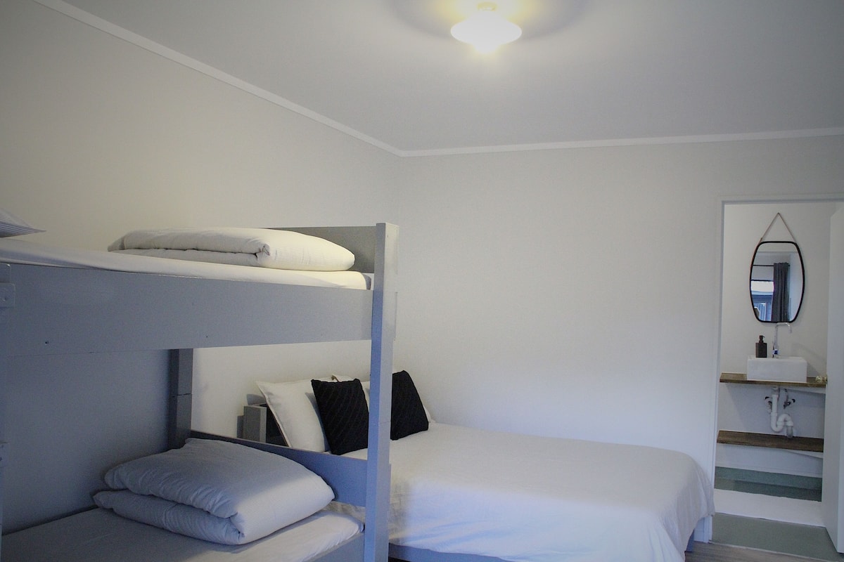 A bunk bed room with a mirror and a sink.