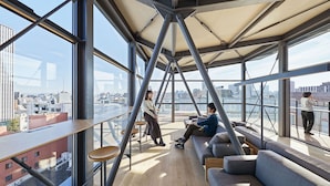 Un interior moderno con techo alto, ventanas amplias y vistas a la ciudad.