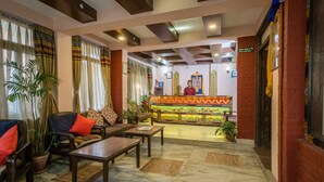A hotel lobby with a reception desk, seating area, and decorative elements. - Hotel Yambu (Kathmandu)