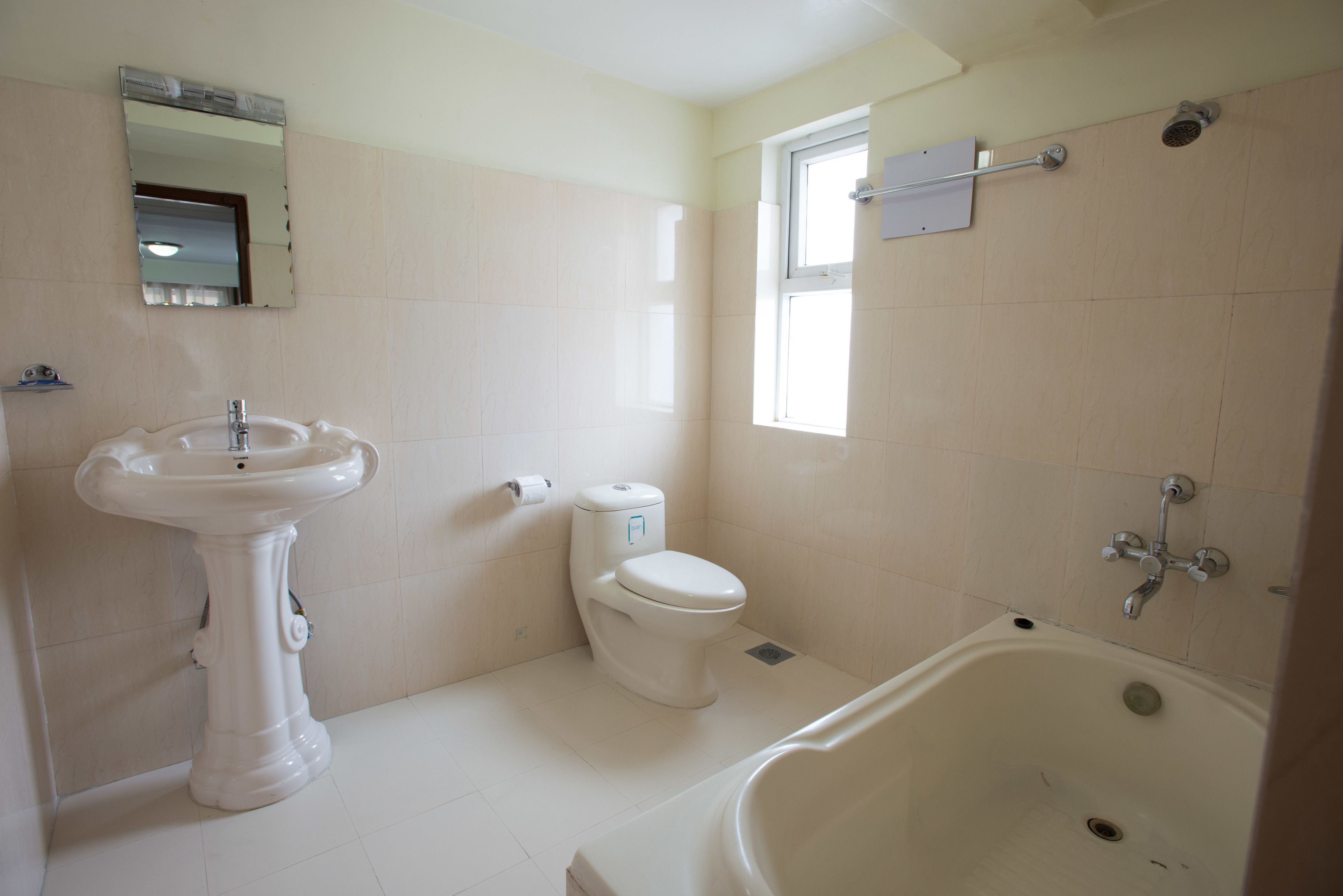 A bathroom with a pedestal sink, toilet, and bathtub.