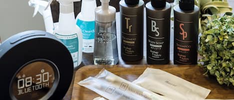 A variety of toiletries including body soap, shampoo, and hand soap on a wooden table.