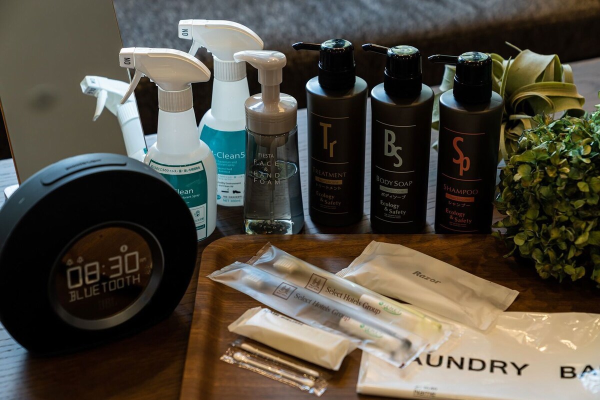 A variety of toiletries including body soap, shampoo, and hand soap on a wooden table.