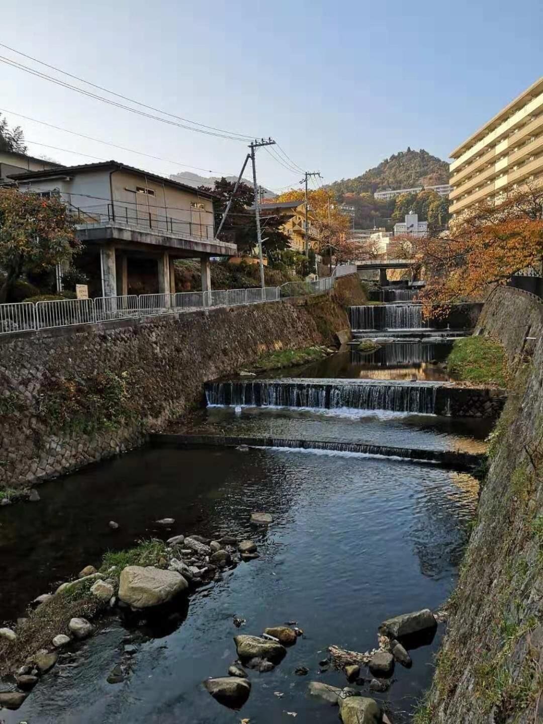 A small river with a bridge and buildings in the background.