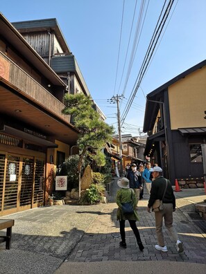 Un edificio tradicional japonés con fachada de madera y un letrero que indica que es un hotel.