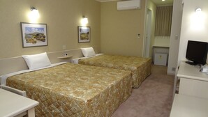 A hotel room with two beds, a desk, a television, and two wall-mounted lights. - Family Lodge Hatagoya Chichibu (Chichibu)