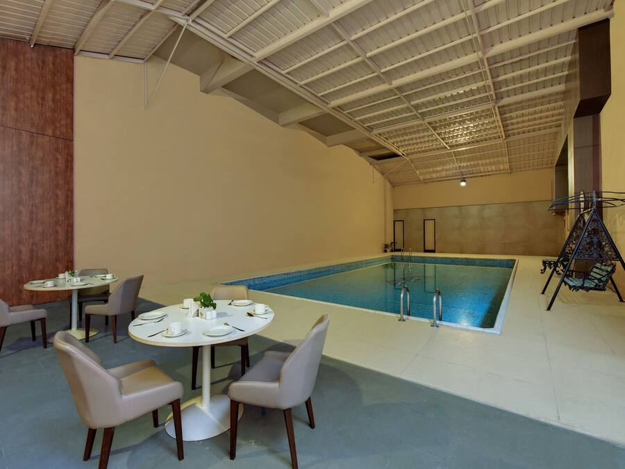 Een binnenzwembad, ligstoelen bij het zwembad