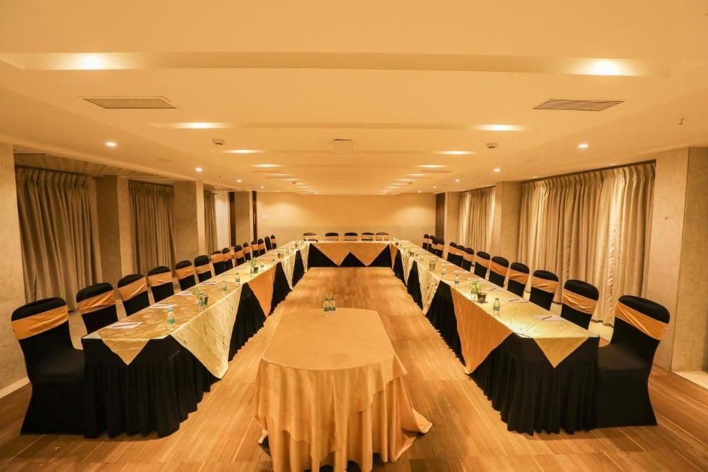 Un salón de conferencias con una mesa larga, sillas y un mantel.