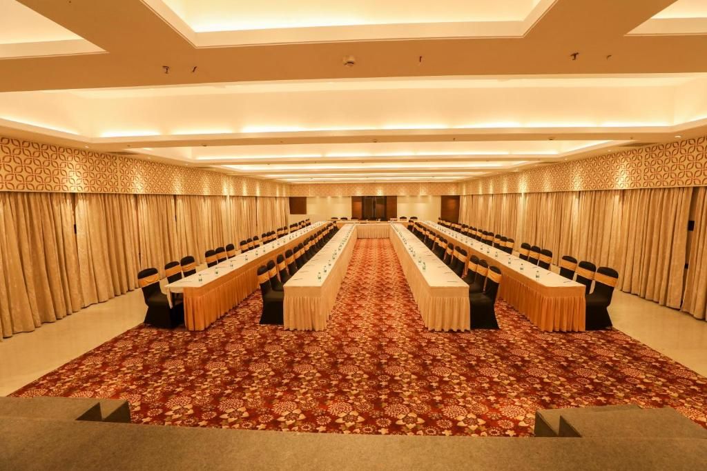 A conference room with a long table, chairs, and a patterned carpet.