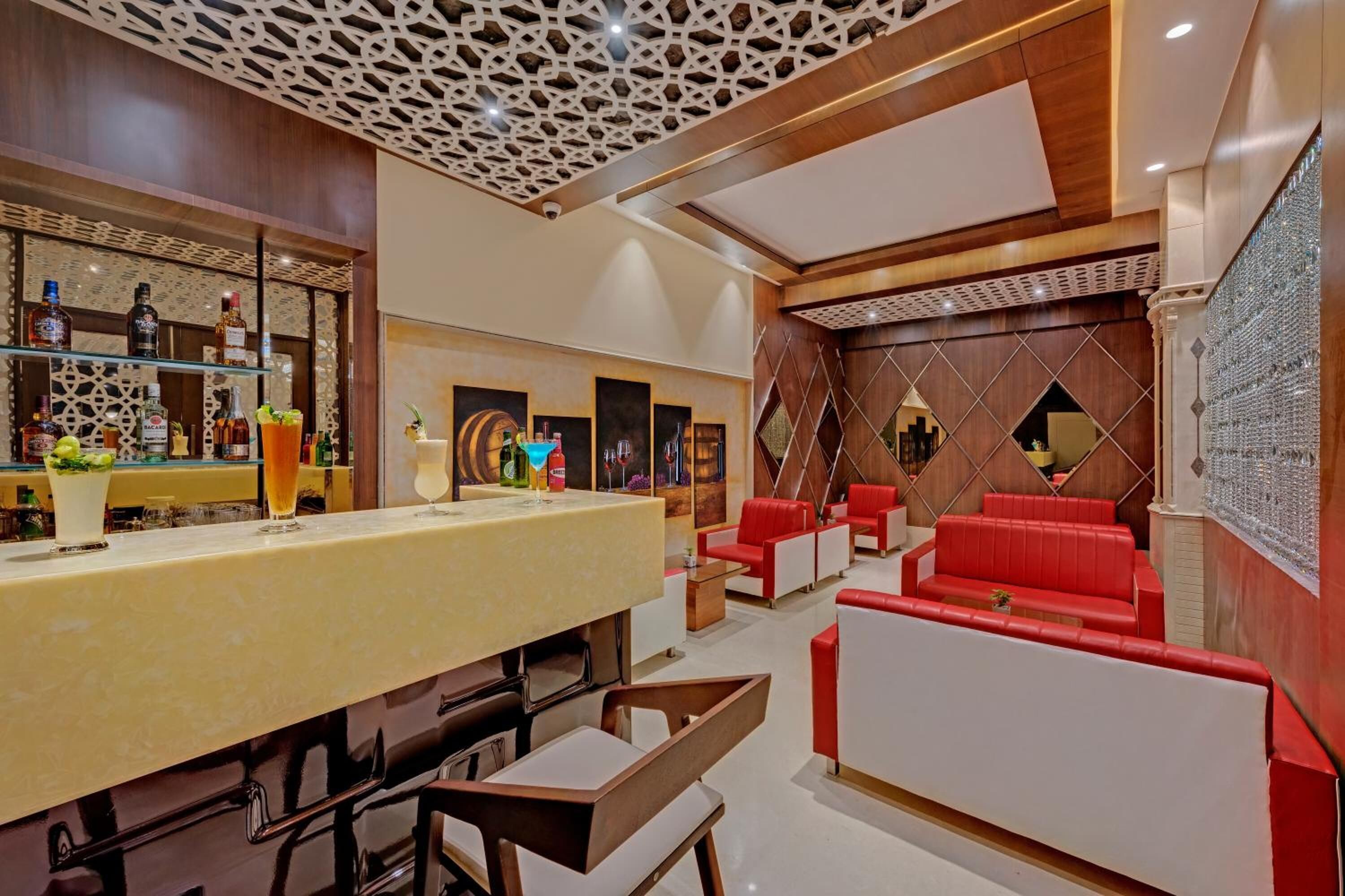 A modern bar area with a counter, seating, and decorative wall panels.