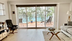 Amplia sala de estar con un gran ventanal corredero que da a un patio exterior.