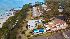 Un área residencial costera con casas, una playa y una vista despejada del océano.