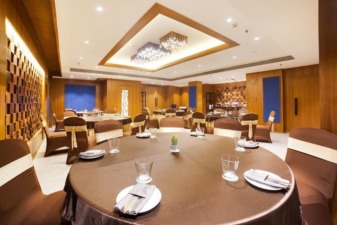 A conference room with a large oval table, multiple chairs, and a chandelier.