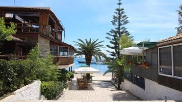 Un patio con piscina, mobiliario exterior y vistas al mar.