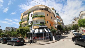 Um edifício de vários andares com um bar chamado "BAR JUVENTUS" no andar térreo.