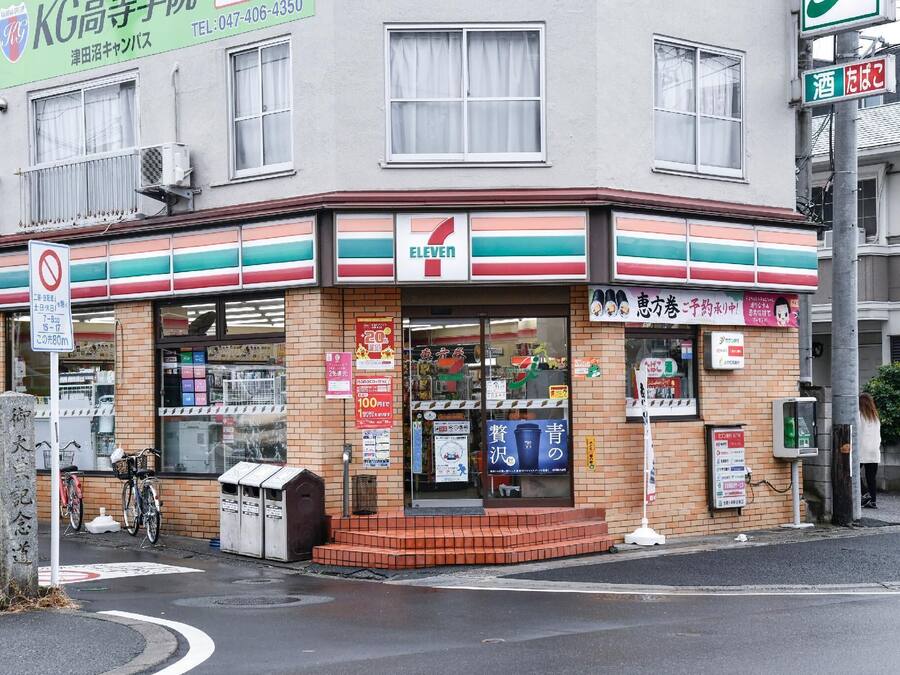 A 7-Eleven convenience store with a brick facade, large windows, and a visible entrance.