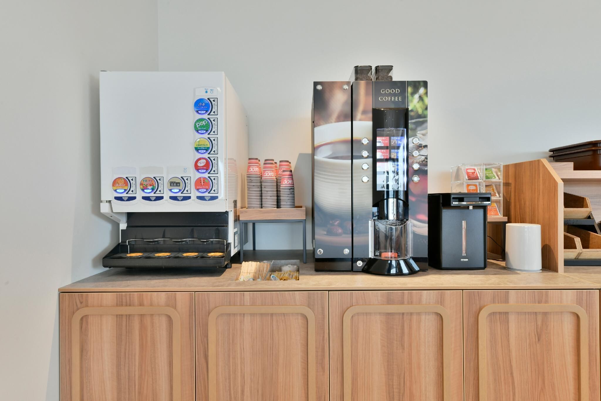 A coffee station with a coffee machine, a grinder, and a coffee dispenser.