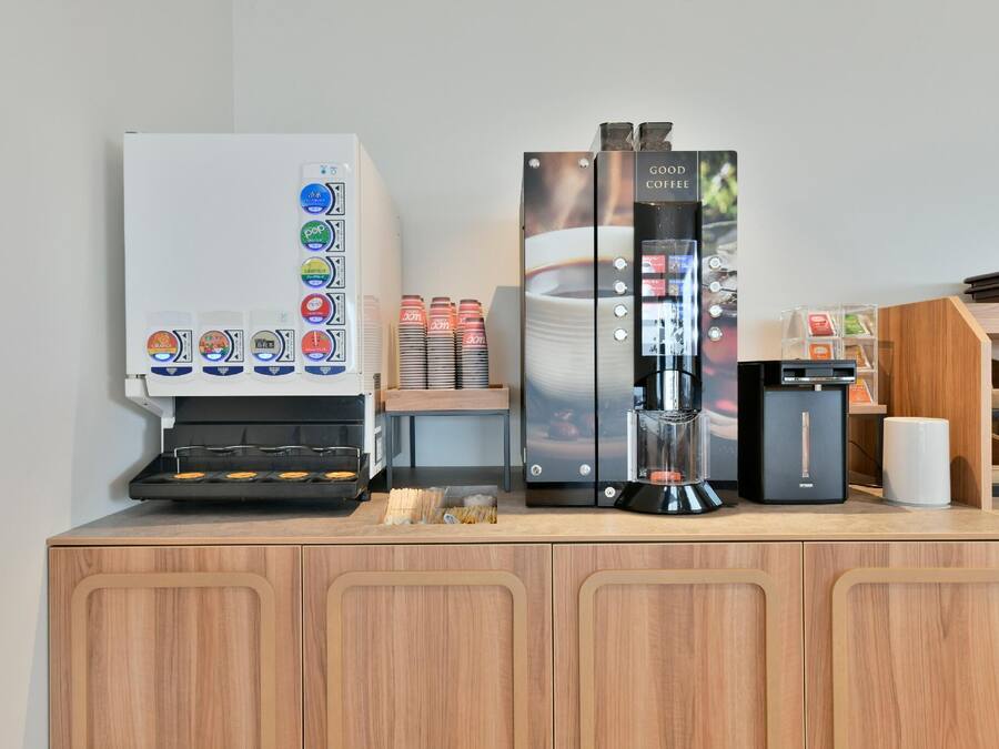 En kaffestation med kaffemaskine, kværn og kaffedispenser.