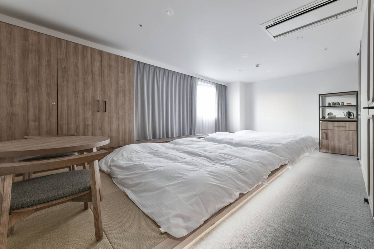 Een moderne hotelkamer met een groot bed, een bureau en een kledingkast.