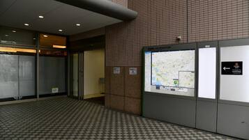 A tiled floor with a checkered pattern, a map display, and a sign indicating a no-smoking area.
