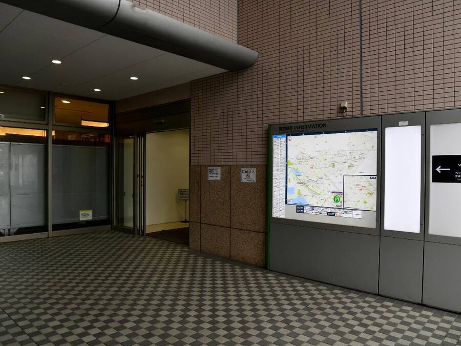 A tiled floor with a checkered pattern, a map display, and a sign indicating a no-smoking area.