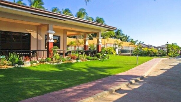 A modern house with a covered porch, a well-maintained lawn, and a paved driveway.