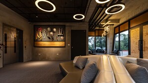 Un espacio lounge moderno con un sofá, una obra de arte en la pared y vistas al exterior.