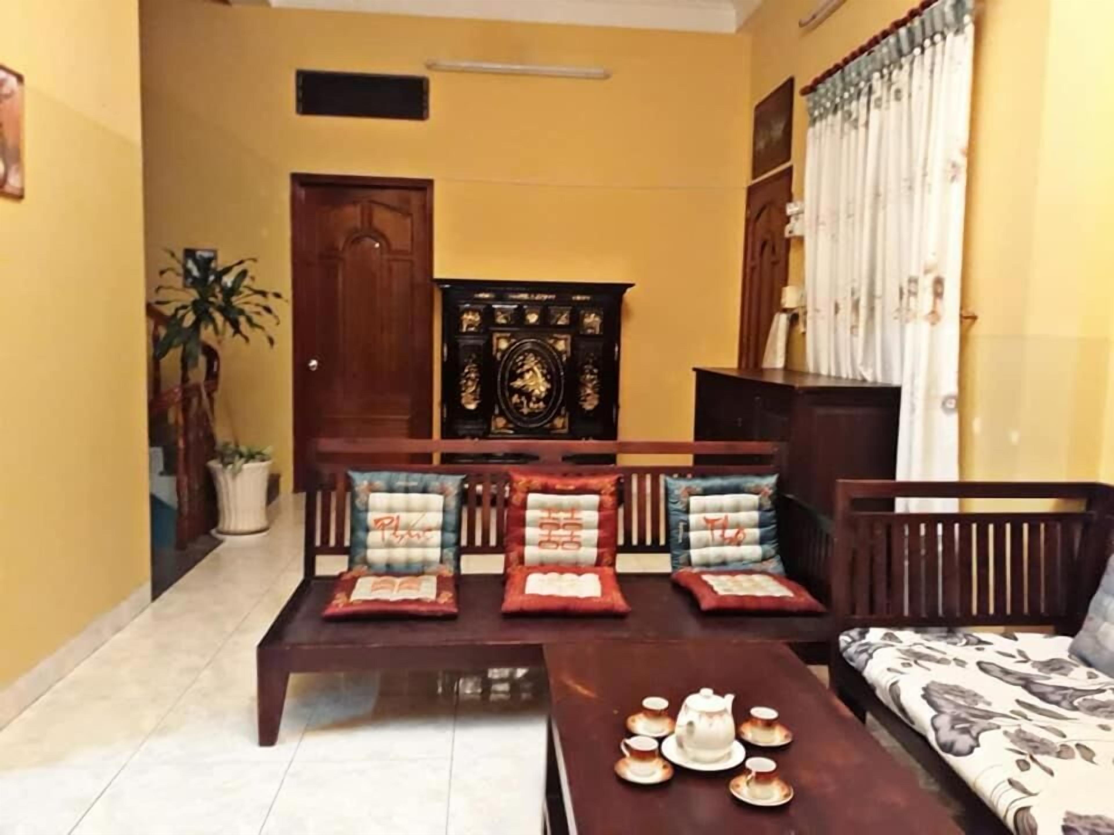 A living room with a sofa, a coffee table with teacups, a cabinet, and a door.