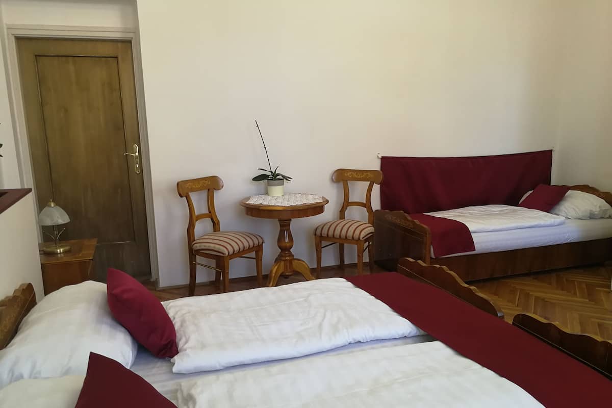 A room with two beds, a table, and two chairs.