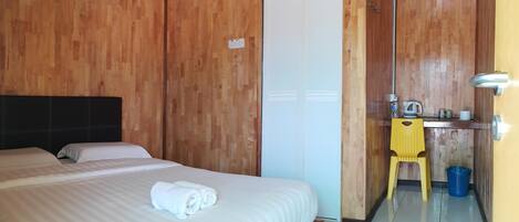 Habitación de hotel con cama, escritorio, silla, espejo y armario.