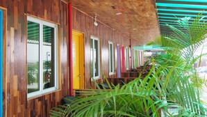 A wooden corridor with colorful doors and windows, leading to a staircase. - Mabohai Resort Klebang (Malacca City)