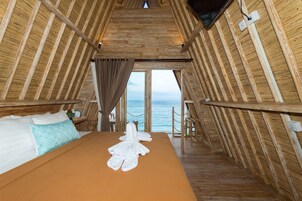 Una habitación con una cama, vistas al mar y paredes de madera.