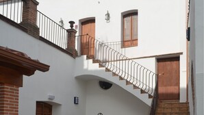 A spacious courtyard with a wooden staircase leading to an upper level.