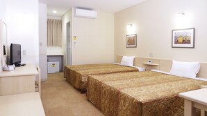 A hotel room with two beds, a desk with a computer, a small refrigerator, and a wall-mounted air conditioner. - Family Lodge Hatagoya Tsukuba (Tsukuba)