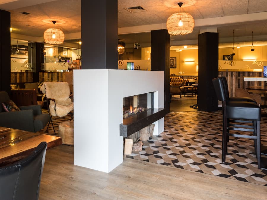 Un interior moderno con suelo a cuadros, chimenea y zona de bar.