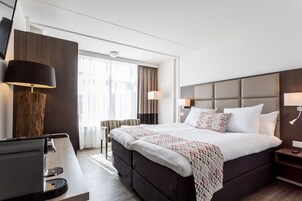 Ropa de cama hipoalergénica y caja de seguridad en la habitación 