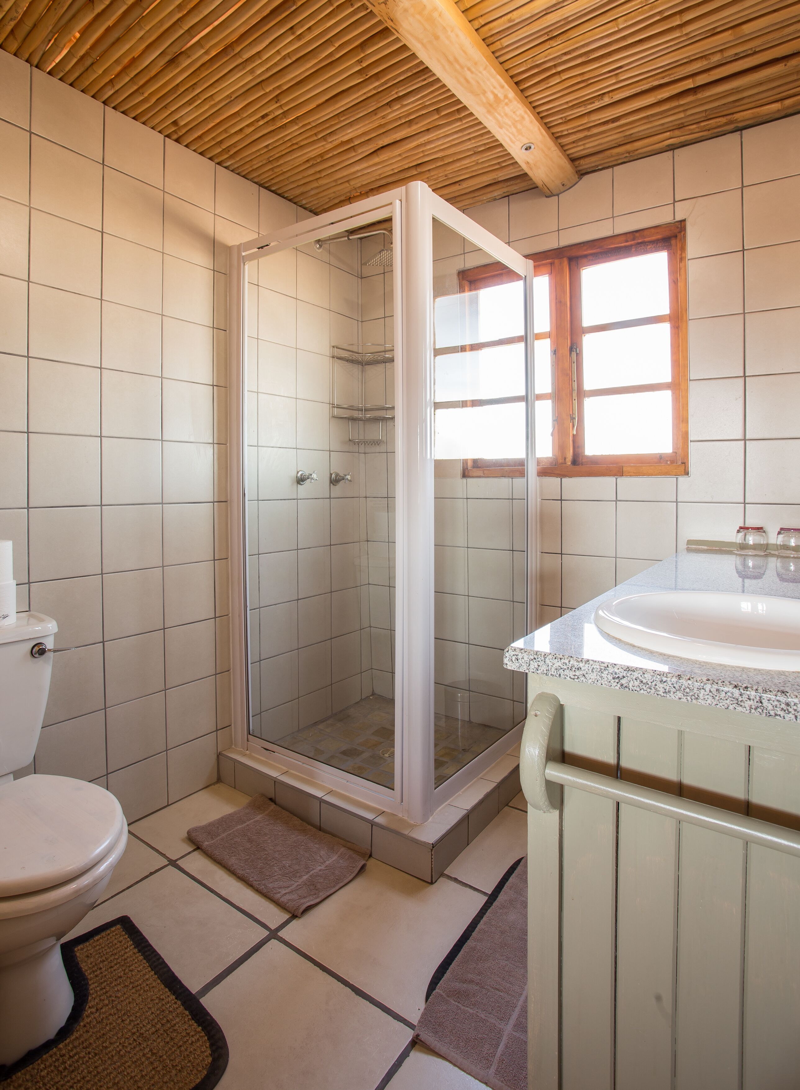 A bathroom with a shower, toilet, and sink.