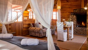 A cozy log cabin room with a bed, a sofa, and a dining table. - Soetdoring Selfsorg (Oudtshoorn)