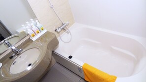 Ein Badezimmer mit einer Badewanne, einem Waschbecken und Pflegeprodukten.