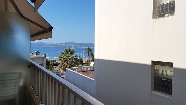 Un balcón con vistas al mar y montañas a lo lejos.