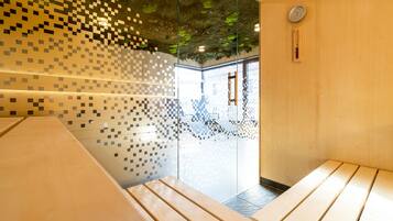 Un intérieur moderne avec des murs en verre, des bancs en bois et un plafond orné d’un motif pixélisé.