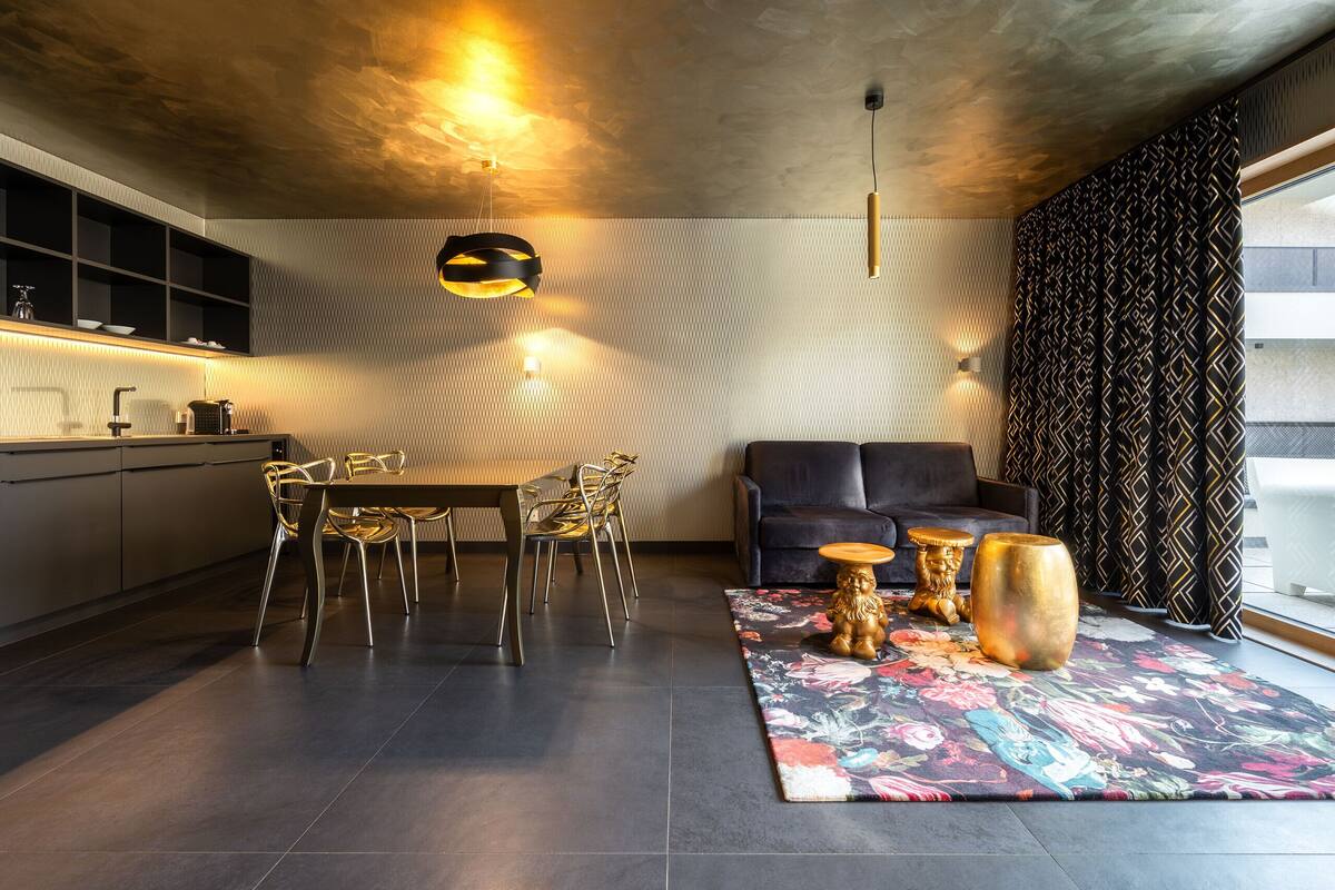 Une cuisine moderne avec un coin repas, un canapé et des objets décoratifs disposés sur un tapis.