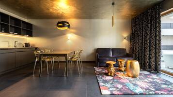 A modern kitchen with a dining area, a sofa, and decorative items on a rug.