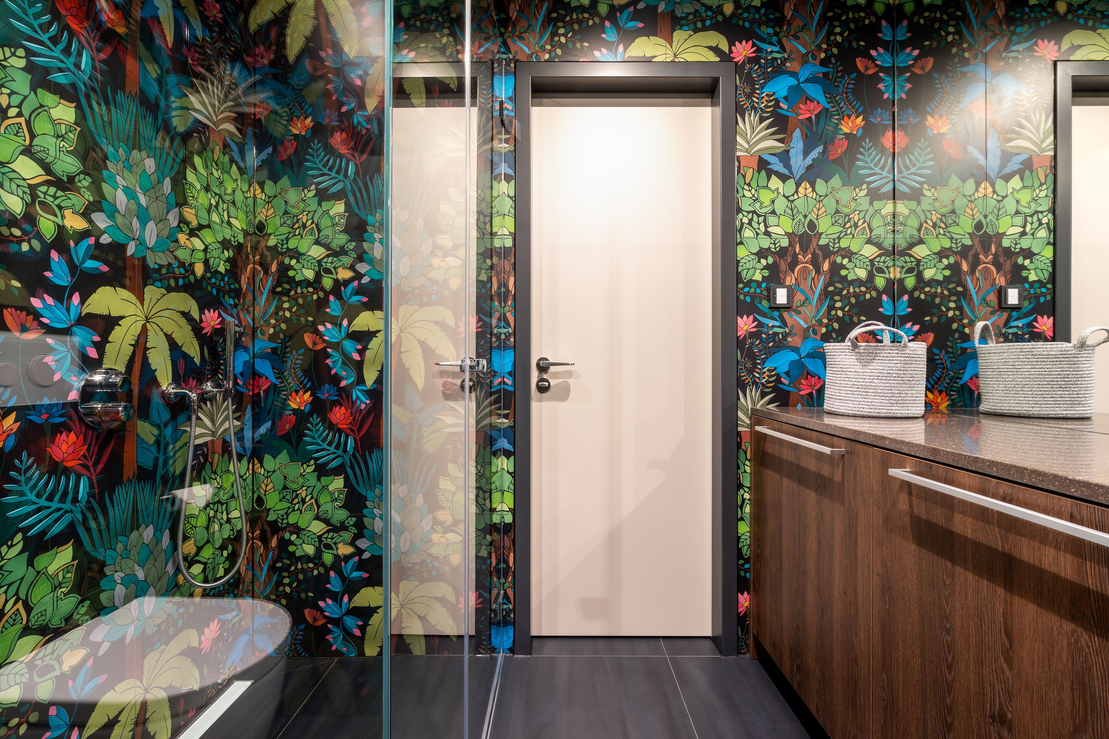 A bathroom with a glass shower enclosure, a wooden vanity with a mirror, and a toilet.