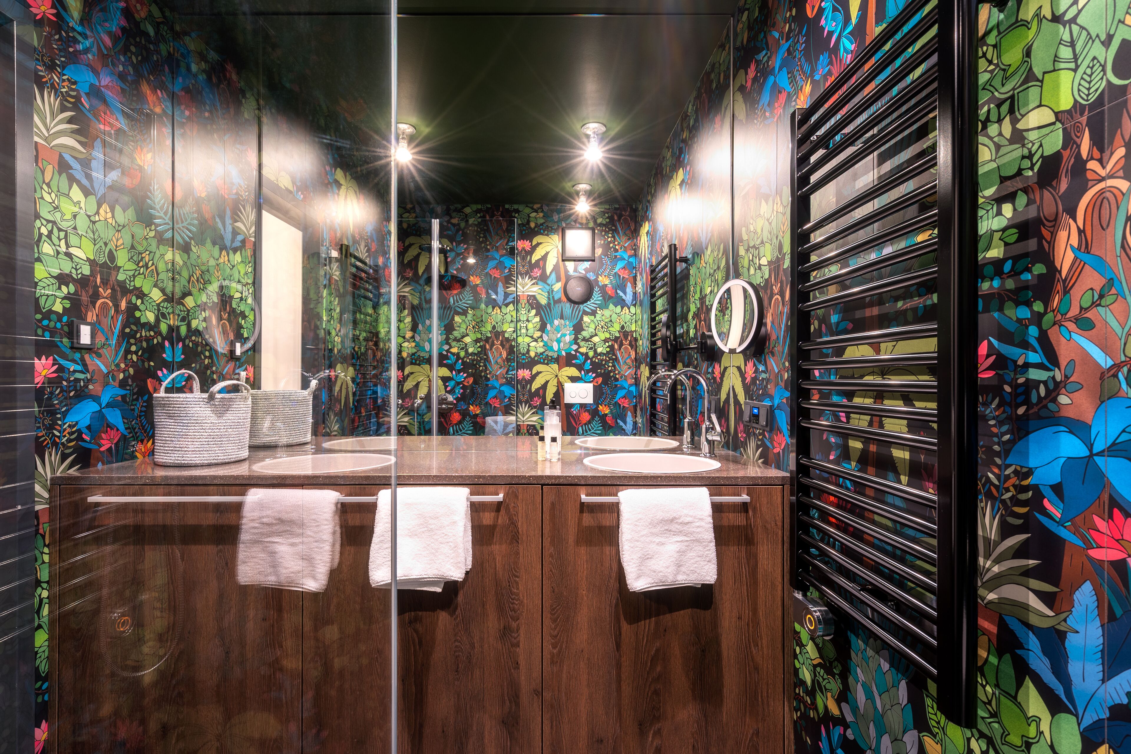 A bathroom with a wooden vanity, two sinks, and a mirror.