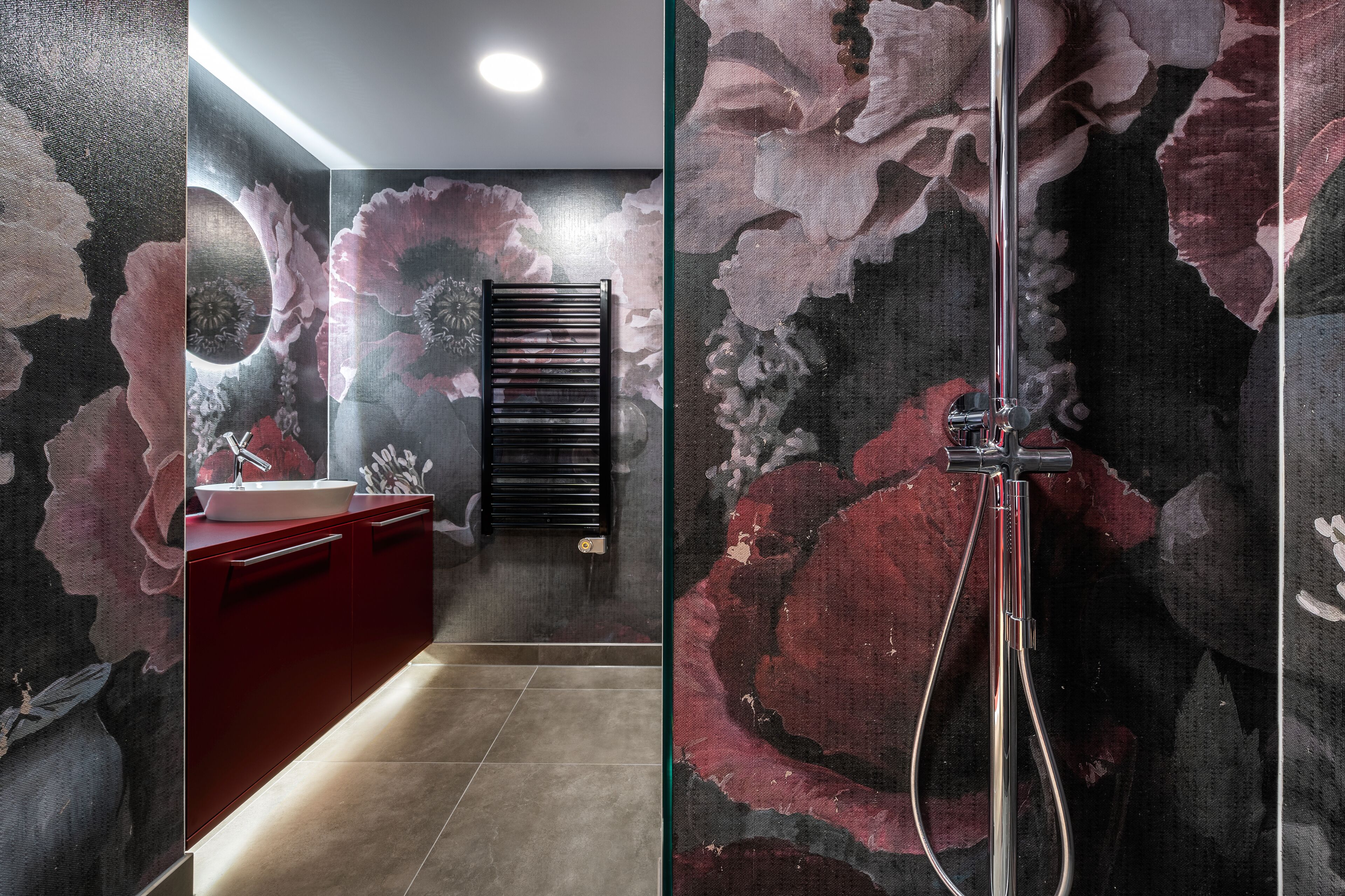 A modern bathroom with a large mirror, a sink, and a shower.