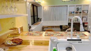 Una cocina con encimera de madera, un lavamanos y una ventana con cortinas.