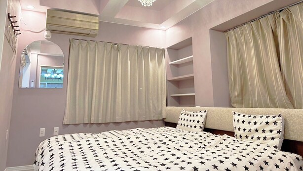 Un dormitorio con cama, candelabro, espejo y armario.
