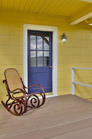 Relax on the porch with a comfortable rocking chair, surrounded by a charming outdoor space.