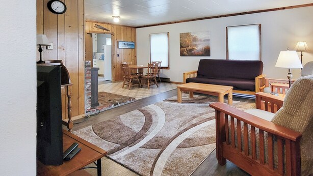 A cozy living area with a sofa, chairs, a coffee table, and a TV. - Coffee Klatch Cottage - Yellow (Potlatch)